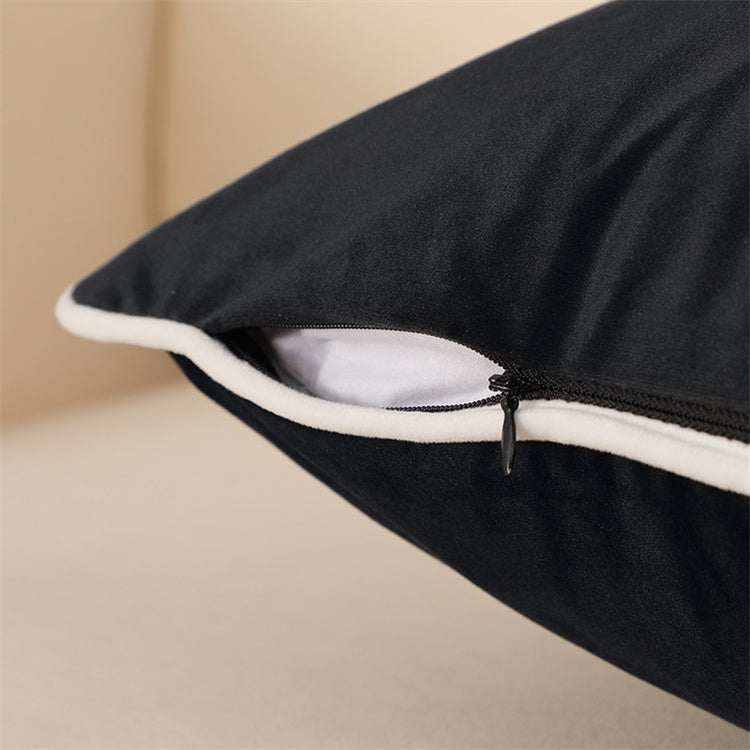 Black velvet cushion with white piping showing its top notch craftmanship and zipper