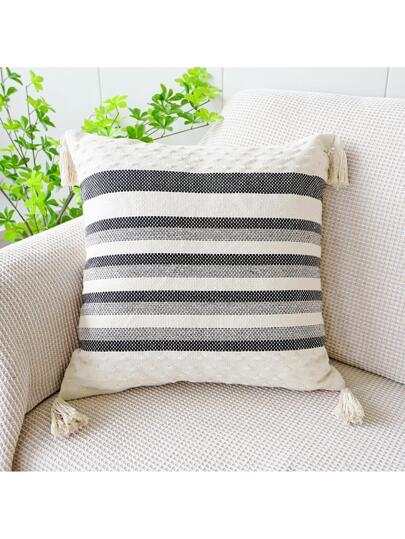 black and grey striped cushion with a white background, tassels on each corner and a textured feel on the bottom and top