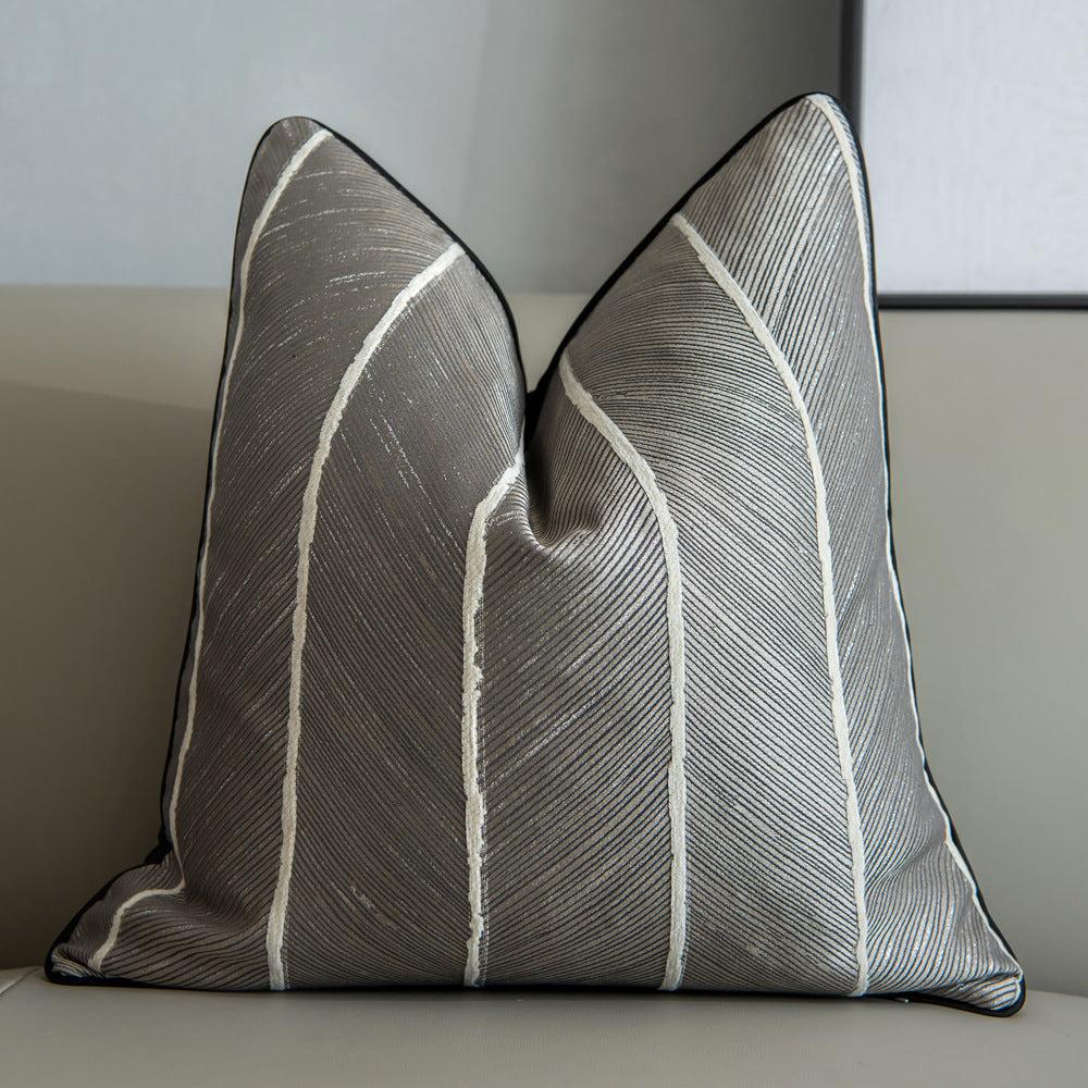 Grey with white stripes running down this affordable luxury cushion with leaf rugged pattern on the cushion