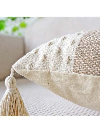 Two shades of khaki striped cushion with a white background, tassels on each corner and a textured feel on the bottom and top close up close up